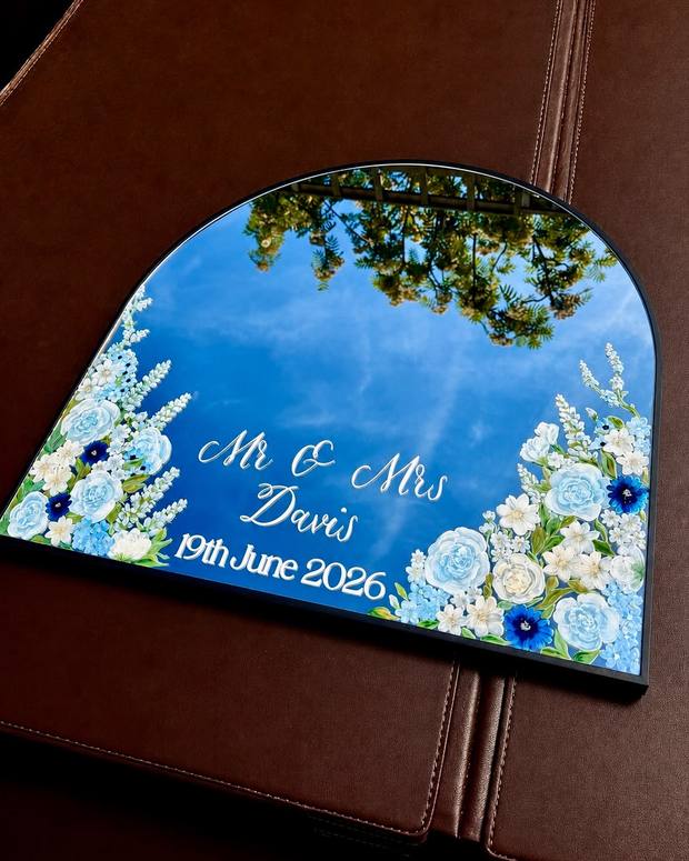 Hand-painted arched wedding welcome mirror with painted blue and white roses, delphiniums and foliage